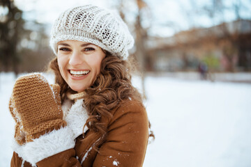 smiling stylish woman outside in city park in winter - obrazy, fototapety, plakaty