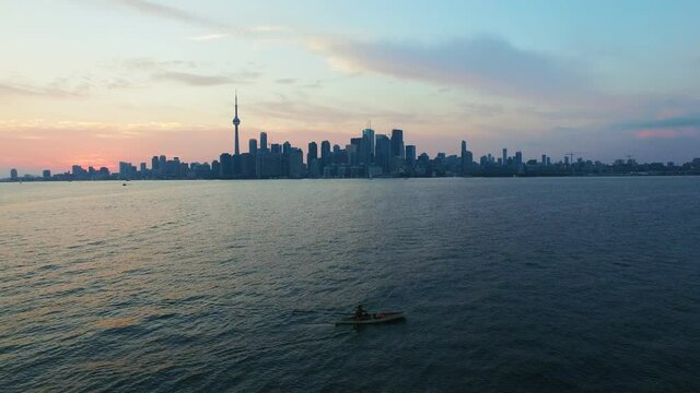 4K Aerial shot of Toronto Skyline at sunset with canoer paddling