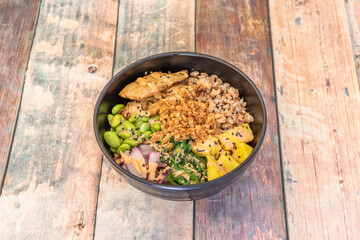 Poke bowl vegan edamame beans, cooked bulgur, crunchy onion, chopped tofu, mango, red onion and wakame seaweed
