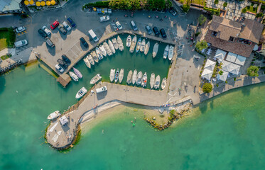 Fototapeta na wymiar Aerial view of a small port of a Sirmione town on a shore of Garda lake in Lombardy, Italy. 