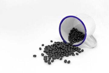 Fototapeta na wymiar Black beans inside a mug and isolated in a white background. 