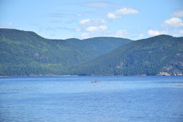 Fototapeta na wymiar Saguenay Fjords National Park, Sepaq, Quebec, Canada: View from the shores of the Baie Éternité, looking northwards with a canoe in the distance