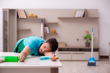 Young male contractor cleaning the house