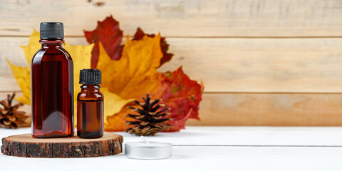 Essential oil bottle for aromatherapy. Autumn skin care concept. Cosmetic serum on a wooden...