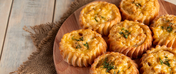 Hot tasty muffins with vegetables and cheese on wooden board. Recipe for autumn seasonal dish. Delicious homemade cakes for healthy diet.