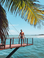 Man at the dock in the beach with sea view and palm trees