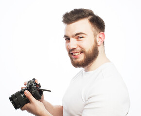 Young bearded photographer wearing glasses looking at photos on the camera screen