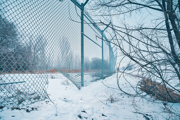 Hole in border fence with barbed wire. Escape from prison or closed institution for mentally ill....