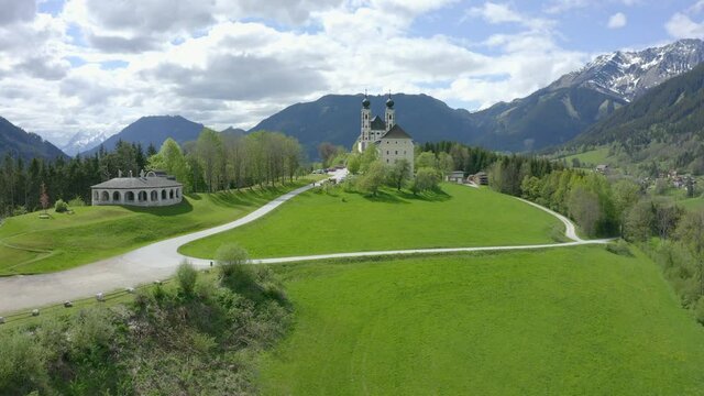 Aerial view moving right shot, Scenic view landscape of castle in Liezen, Austria, bright sunny day and Ammergebirge in the background.