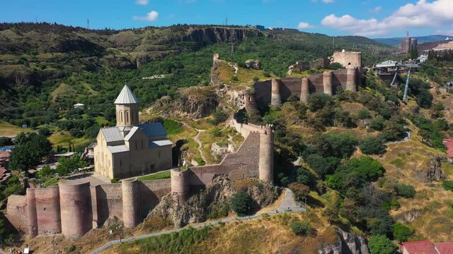 Aerial: Narikala Fortress overlooking Tbilisi capital city in Georgia