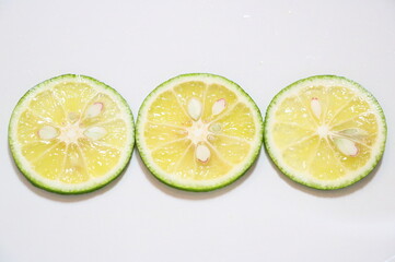 日本の夏の風物詩　すだちの輪切り三つ横並び白バック　コピースぺース有