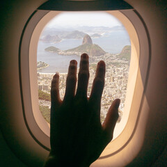 View through a window plane with a hand in Rio de Janeiro