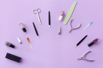 Set of tools for manicure and nail polishes on color background