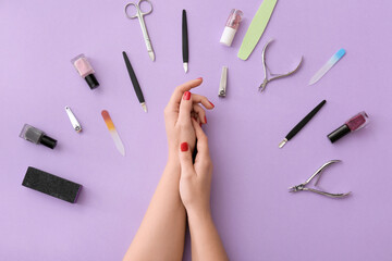 Female hands and tools for manicure on color background
