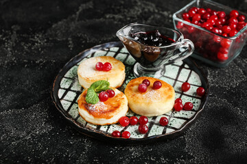 Plate with tasty cottage cheese pancakes. cranberry and jam on dark background