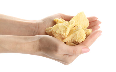 Female hands and pieces of cocoa butter on white background