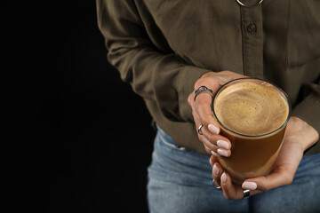 Woman drinking tasty coffee on dark background, closeup