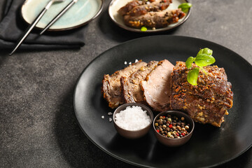 Plate with tasty beef brisket and spices on dark background