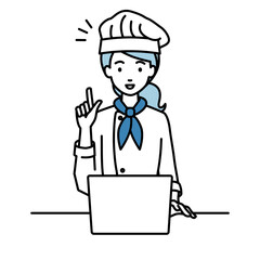 デスクで座ってPCを開いて何かひらめいた調理師の女性