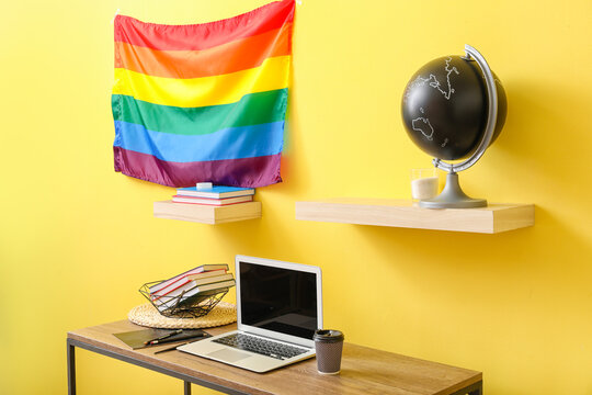 Interior of stylish room with modern workplace and flag of LGBT