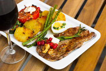 Homemade veal steak with grilled zucchini, tomato, asparagus