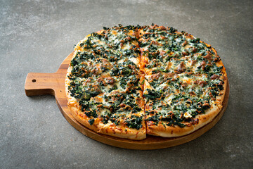 spinach and cheese pizza on wood tray