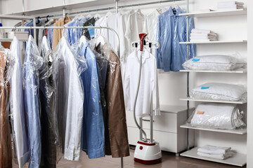 Rack with clothes at modern dry-cleaner's