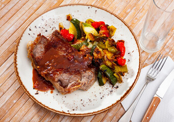Veal steak baked in oven served with assorted braised vegetables