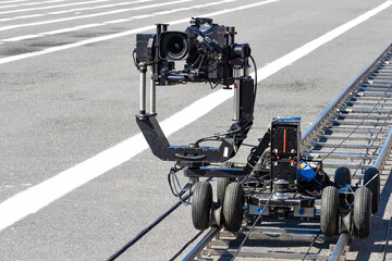 A trolley with video camera on rails. Camera trolley with camera. Cinematography equipment. Concept - rent of operator equipment. Equipment for video filming. Rail trolley for operator.