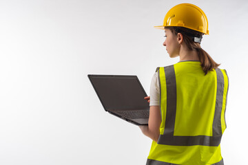 Woman builder in helmet. Builder while working with laptop. Construction worker with computer in his hands. Portrait of woman engineer on white background. Girl in uniform of construction company.