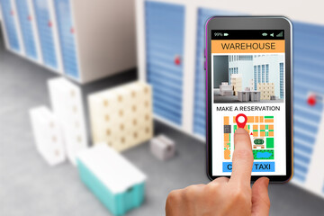 storage company website. Rental Storage Units using smartphone. Make reseration warehouse. Man's hand using phone. Sellphone with site for rental storage. Blurred warehouse corridors in background.