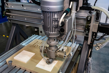 Milling equipment. Milling machine during work. Process of carving something out of wood. Machine during engraving. Cutting of plastic elements. Milling machine cuts out of white plastic.