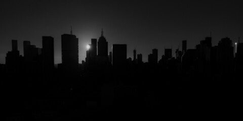 Melbourne city skyline silhouetted by a dramatic sunset in black and white