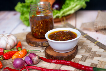 Sambal Bawang, Onion Chili Sauce on wooden fan, decorated with onions, chilis, and vegetables like carrot, salad, eggplant