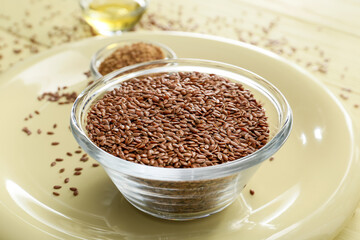 Bowl with flax seeds on table, closeup