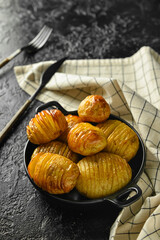 Dish with tasty baked potato on dark background
