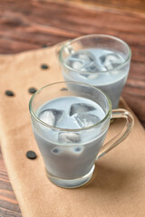 Glass cups of tasty Charcoal Latte on wooden background