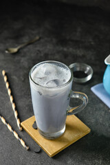 Glass cup of tasty Charcoal Latte on dark background