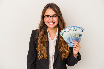 Young caucasian business woman holding banknotes isolated on white background happy, smiling and cheerful.