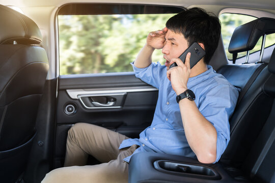 stressed man talking problem on a mobile phone while sitting in the back seat of car