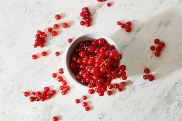 Bowl with fresh red currants on light background