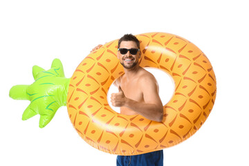 Young man with inflatable ring showing thumb-up on white background