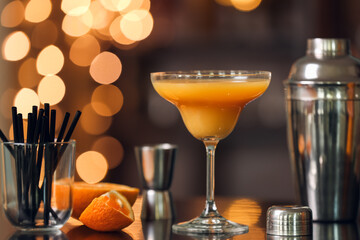 Glass of orange margarita cocktail on table in bar