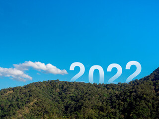 Happy New year 2022 with large letters on the lush green fertile mountains and blue sky, beautiful view with copy space, a successful concept. Welcome, Merry Christmas, and Happy New Year in 2022.