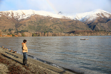 Fototapeta na wymiar A woman standing at the edge of lake Wanaka in New Zealand.