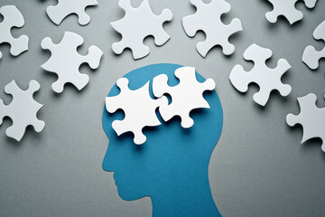 Intellectual mind image. Connecting two jigsaw puzzle pieces. Blue person head silhouette.