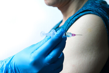 doctor's hand holds a syringe and a blue vaccine bottle at the hospital. Health and medical concepts.