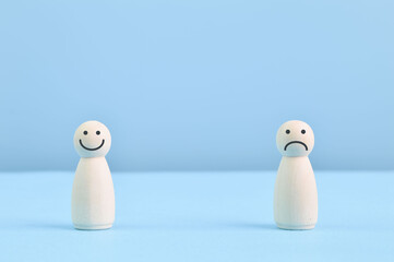Wooden doll figures with smile and sad face. Customer evaluation and satisfaction concept