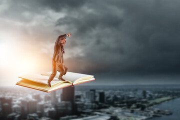 Businessman balancing on top of the flying book