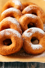 Homemade donuts  with powdered sugar on a wooden baclground